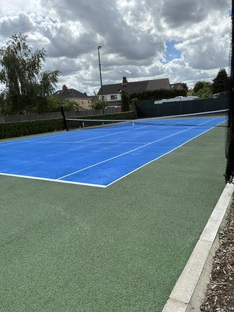Repair work on a hard tennis court showing surface restoration and patching.